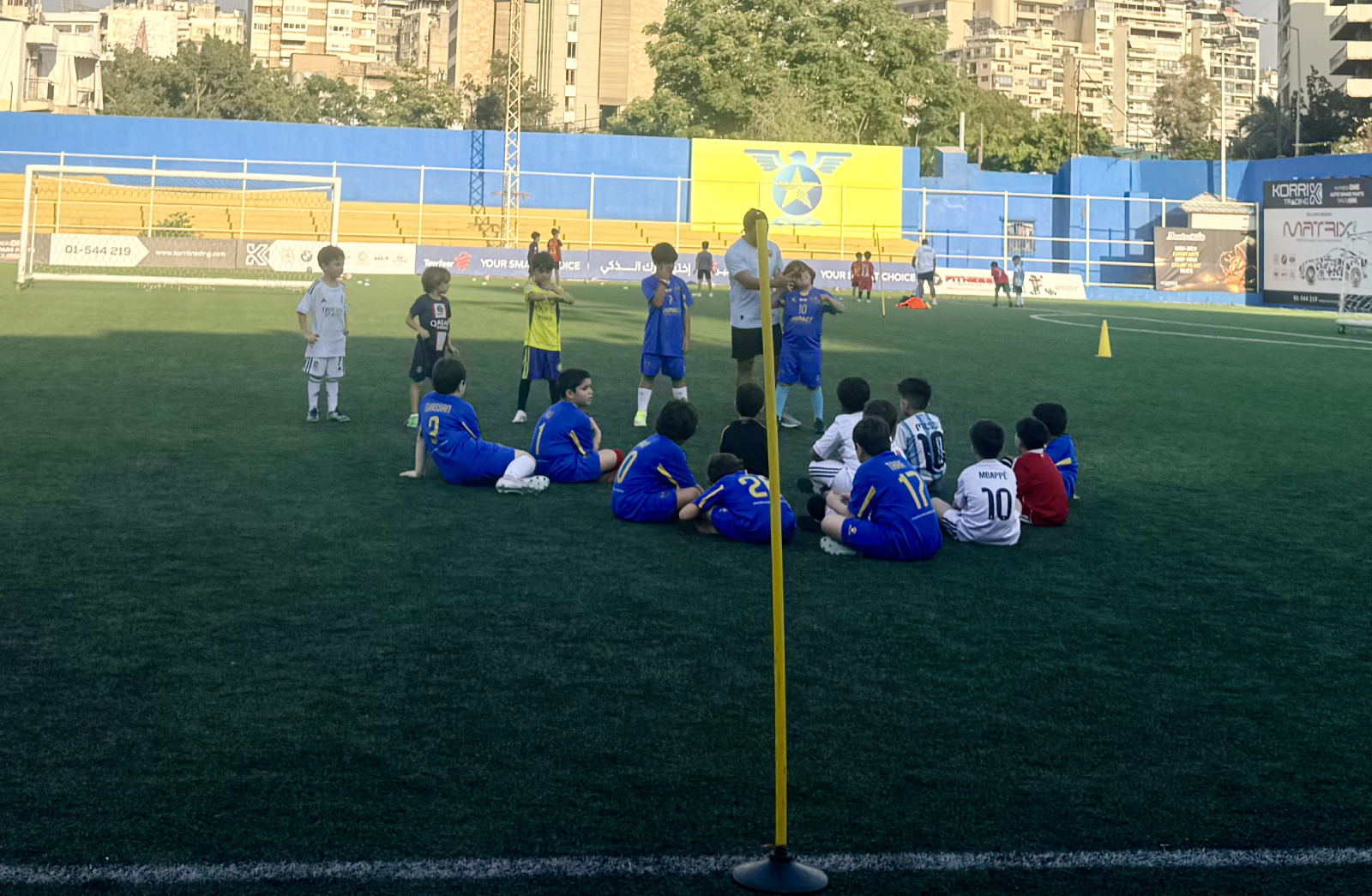 Coach with young ICS players on the pitch